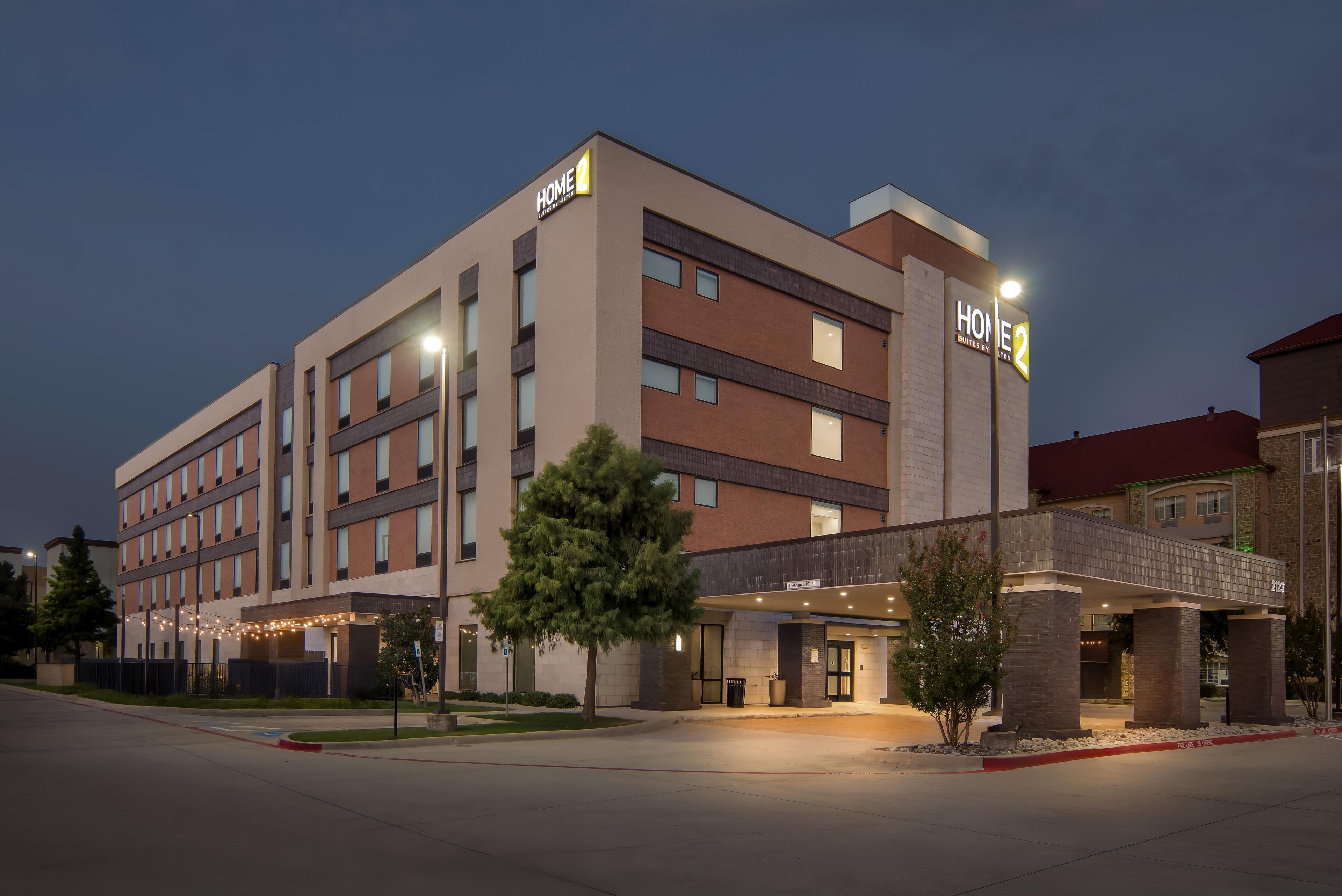 A multi-story hotel with a sign indicating 'HOME 2' and 'Suites by Hilton'.