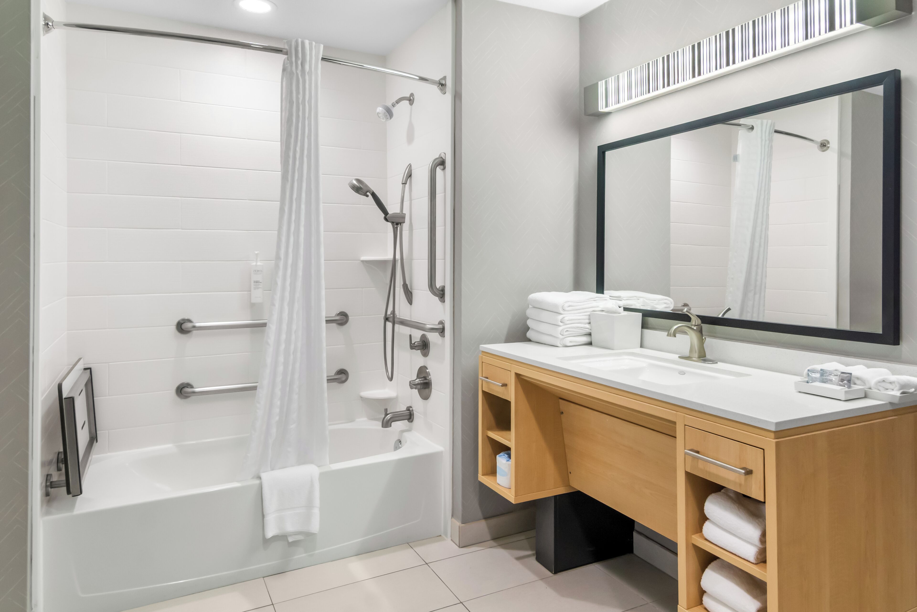 Un baño moderno con cabina de ducha, tocador con espejo y bañera.