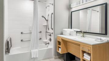 Un baño moderno con cabina de ducha, tocador con espejo y bañera.