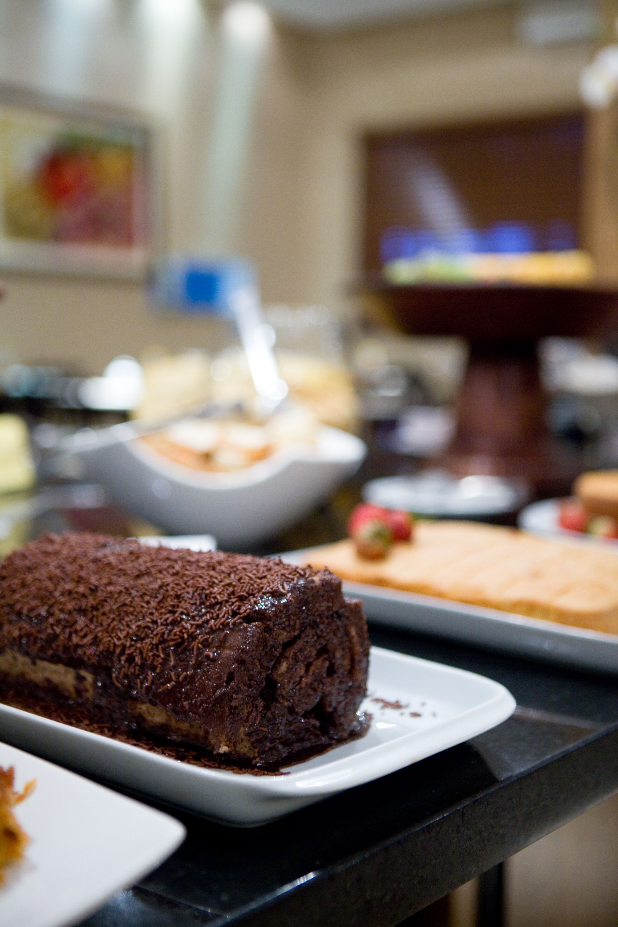 Un buffet proposant une variété de desserts, notamment un gâteau au chocolat et une tarte aux fruits.