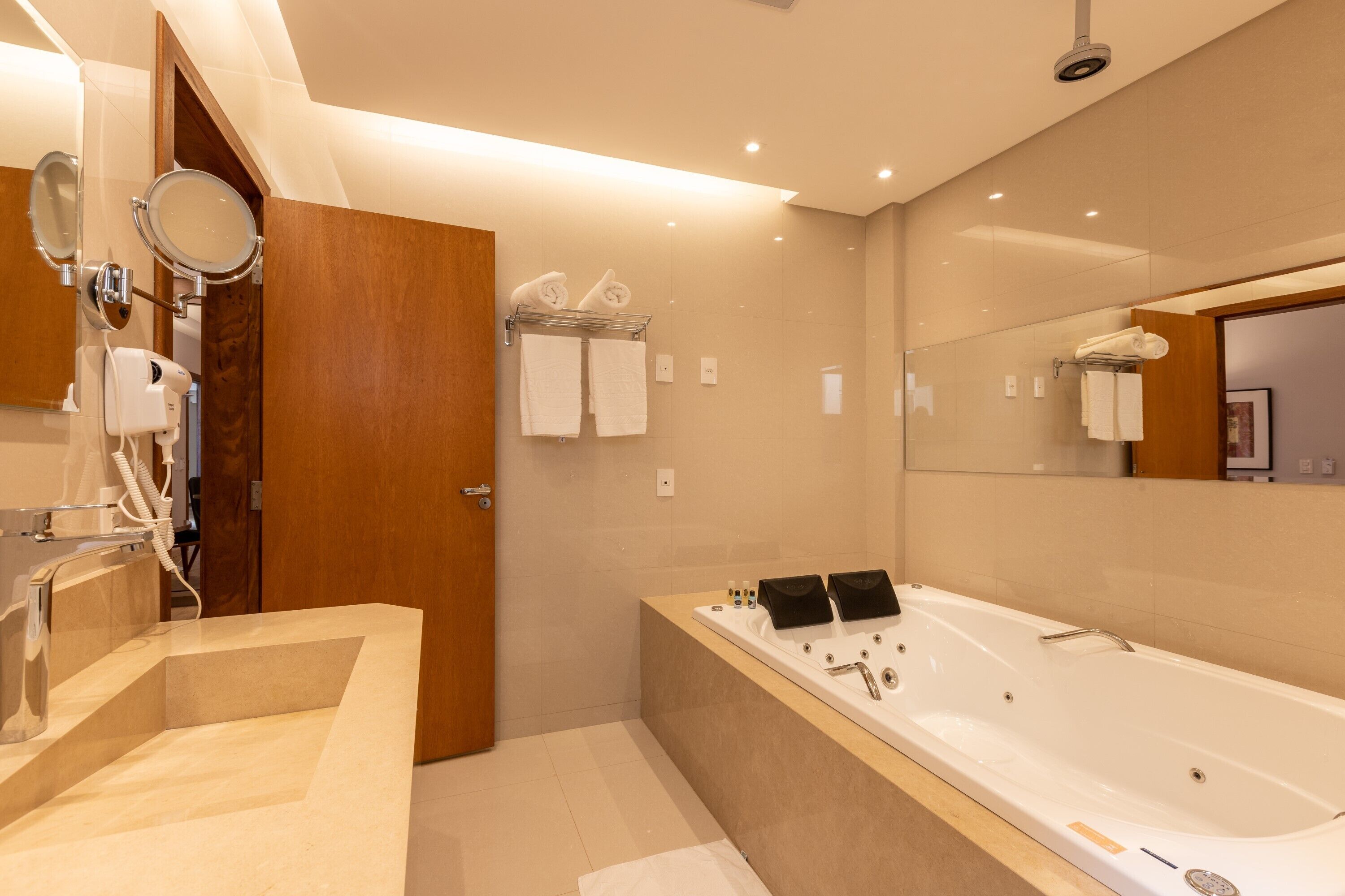 Un baño moderno con una bañera grande, un tocador con espejo y una zona de ducha.