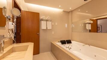 Un baño moderno con una bañera grande, un tocador con espejo y una zona de ducha.