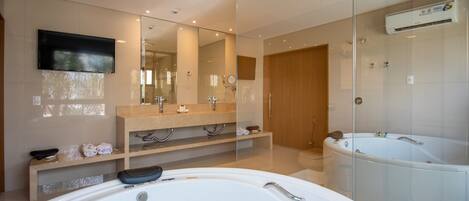 Un baño moderno con una bañera grande, una ducha con cerramiento de vidrio y un tocador con espejo.