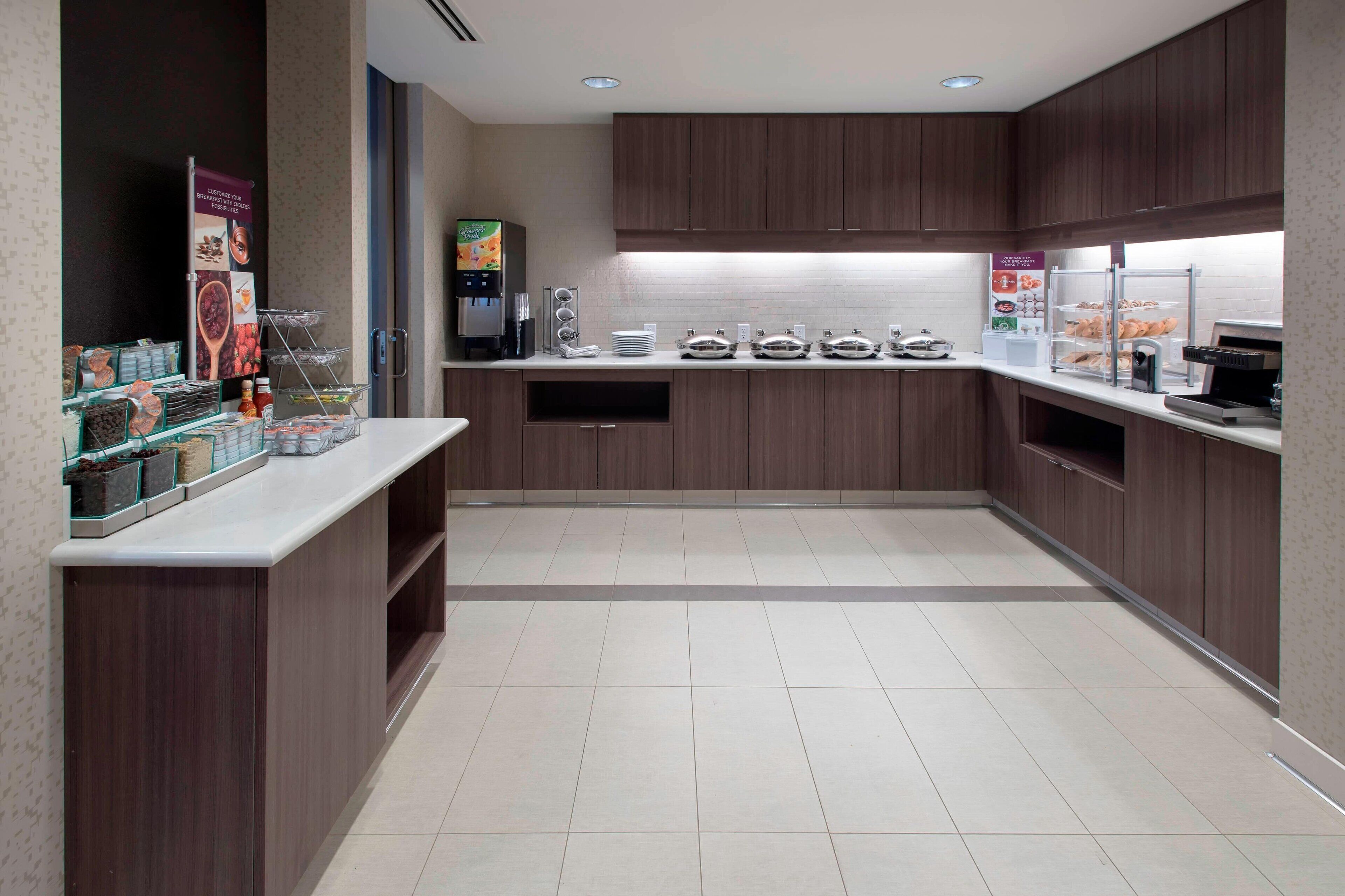 A modern kitchen with a central island, built-in appliances, and a variety of food dispensers.