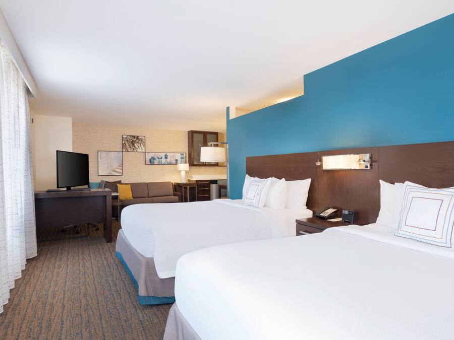 Une chambre d’hôtel avec deux lits, un bureau, une télévision et une salle de bain.