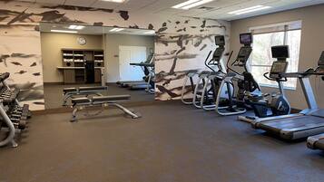 A gym with treadmills, elliptical machines, and weight machines.