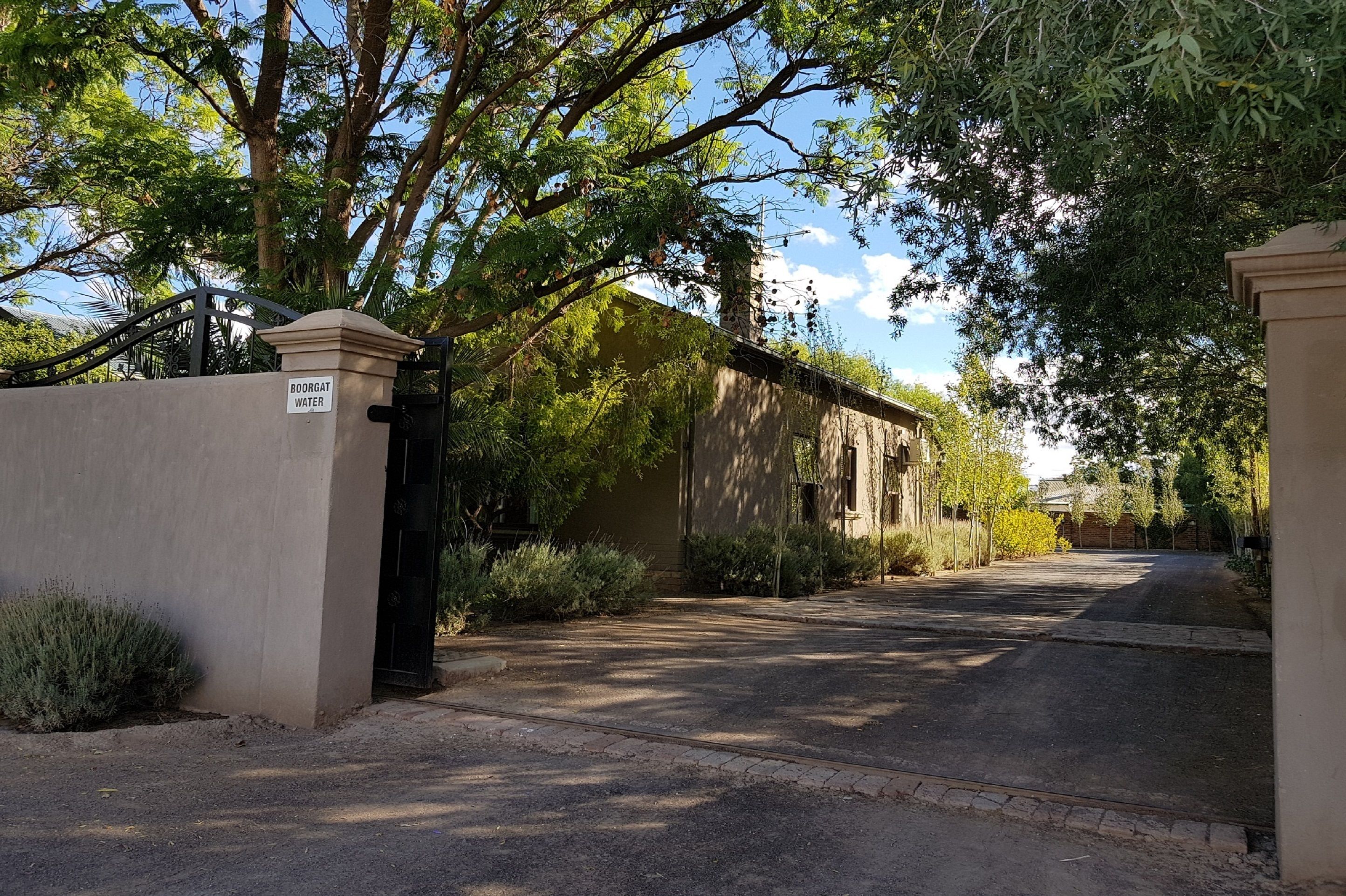 A gated entrance to a building with a sign reading "BOORGAT WATER".