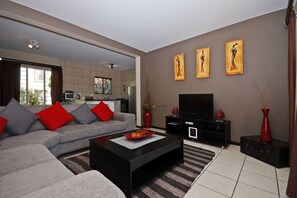 Apartment (Three B) | Living area | 32-inch flat-screen TV with digital channels, TV - Jozi Apartments Radiokop (Roodepoort)