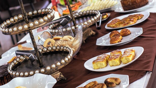 Une table de buffet garnie de divers plats et agrémentée d’un centre de table décoratif.