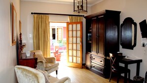 Een woonkamer met een bank, een houten kast, een bureau en een stoel.