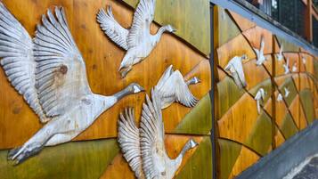 Pared con un panel de madera que presenta una escultura de un pájaro.