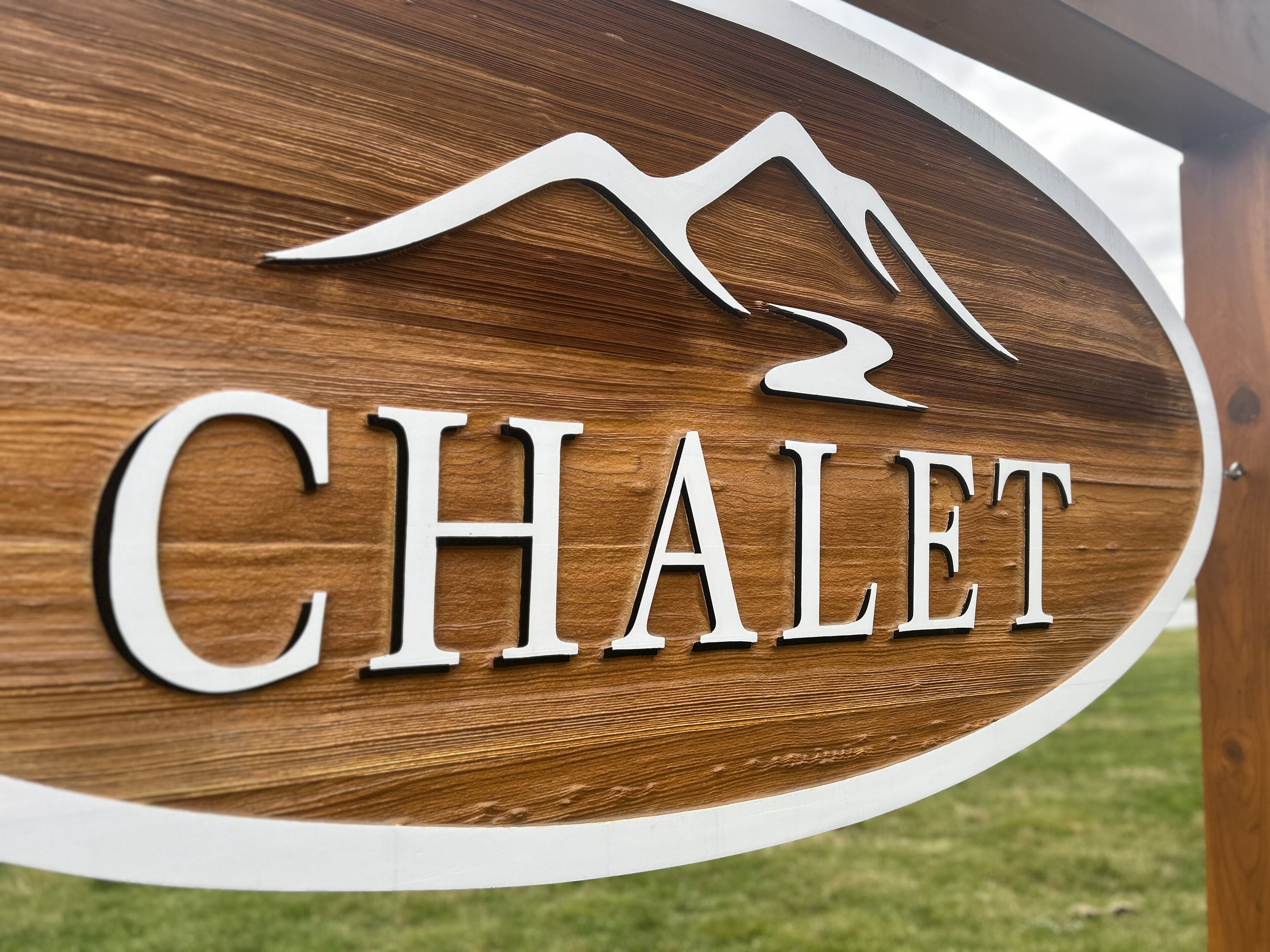 A wooden sign with the word "CHALET" and a mountain silhouette.