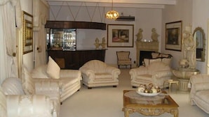 A living room with four armchairs, a coffee table, and a fireplace. - Victorian Guest House (Krugersdorp)