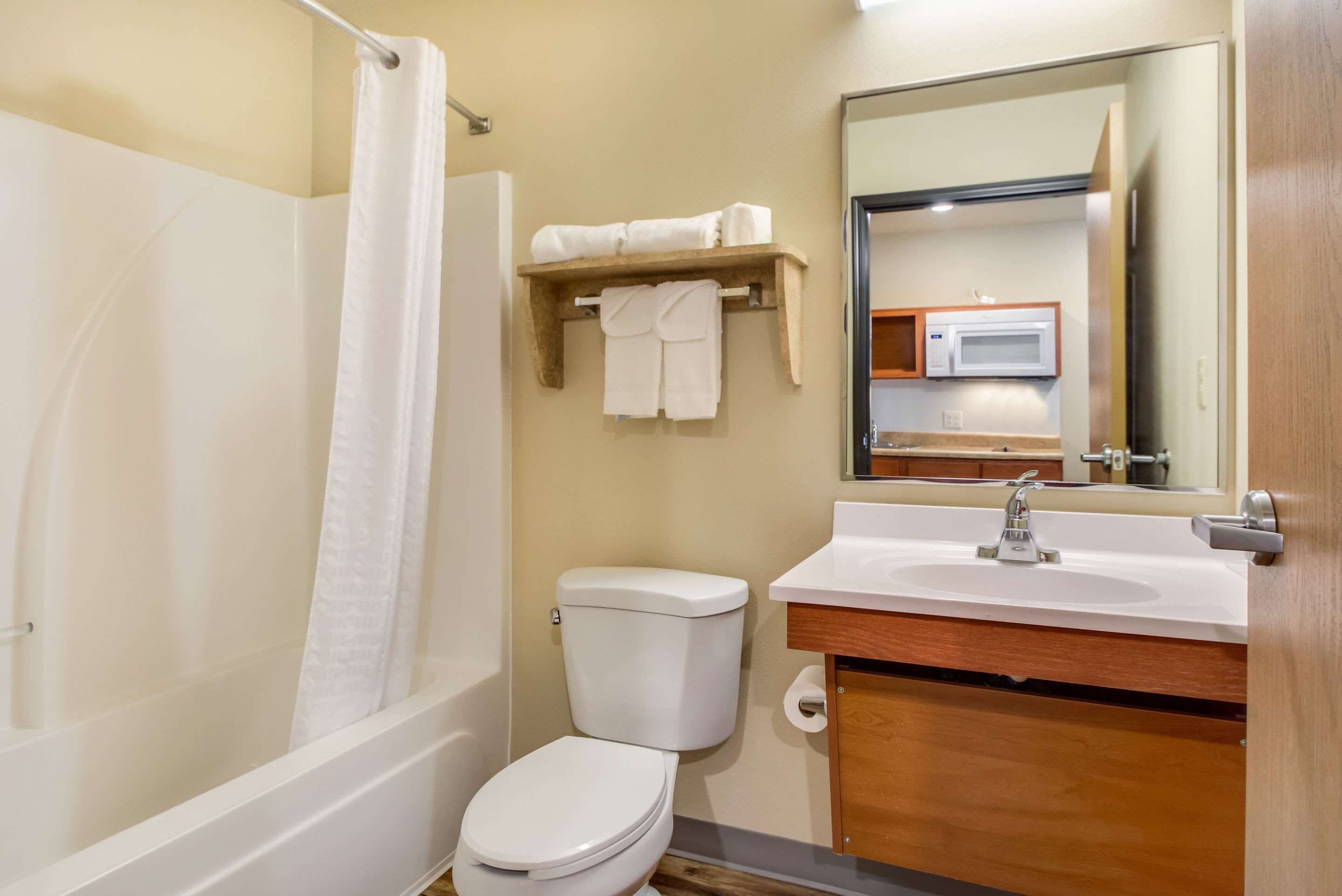 A bathroom with a bathtub, toilet, sink, and a mirror.