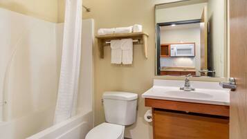 A bathroom with a bathtub, toilet, sink, and a mirror.