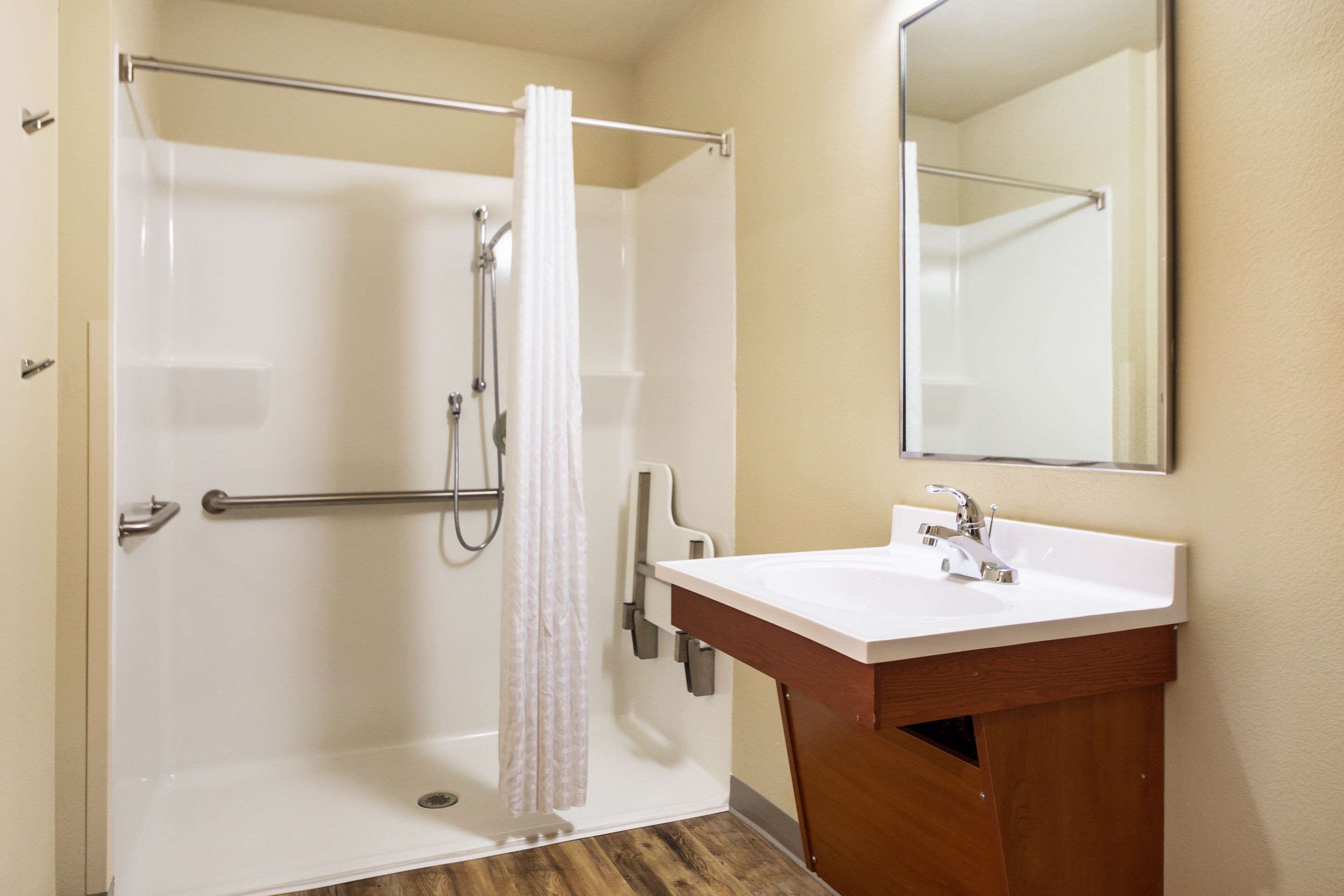 A bathroom with a shower, a sink, and a mirror.