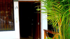 A wooden door with a number '16' above it, a potted plant, and a sign above the door that reads 'Casa Areka'. - Hostel Casa Areka (Panama City)