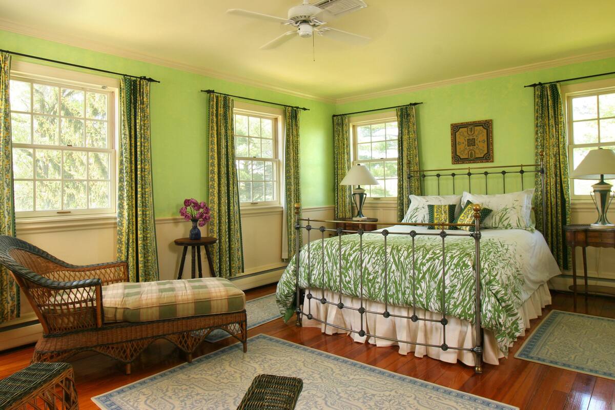 A room with a bed, a chair, a table, and a lamp.