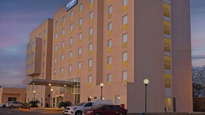 Ein City Express Marriott Hotel mit moderner Fassade, mehreren Etagen und einem Parkplatz mit einigen Autos.