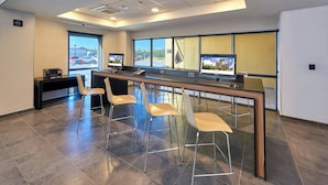 Ein moderner Arbeitsbereich mit einer langen Theke, vier Barhocker und zwei Desktop-Computern.