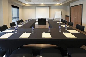 A conference room with a long table, chairs, water bottles, and a projector screen. - City Express by Marriott Reynosa Aeropuerto (Reynosa)