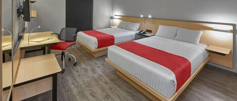 A hotel room with two beds, a desk, and a chair.