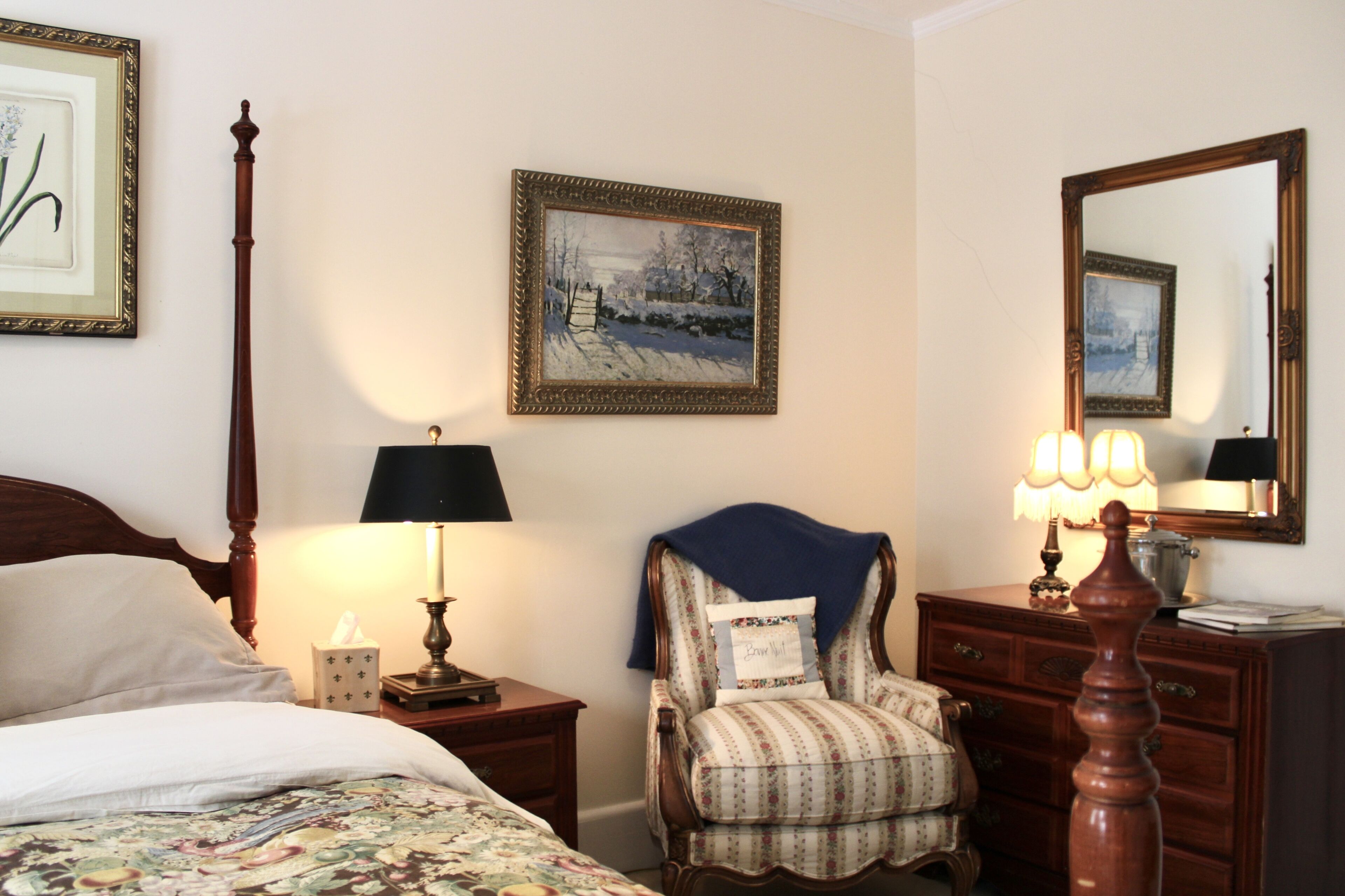 A neatly arranged bedroom with a bed, a chair, a dresser, and a nightstand.