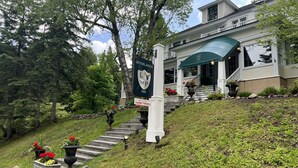 A building with a sign for Interlake Inn, a staircase leading up to the entrance, and a garden with flowers and plants.