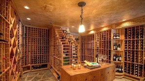 A wine cellar with wooden racks and a central table.