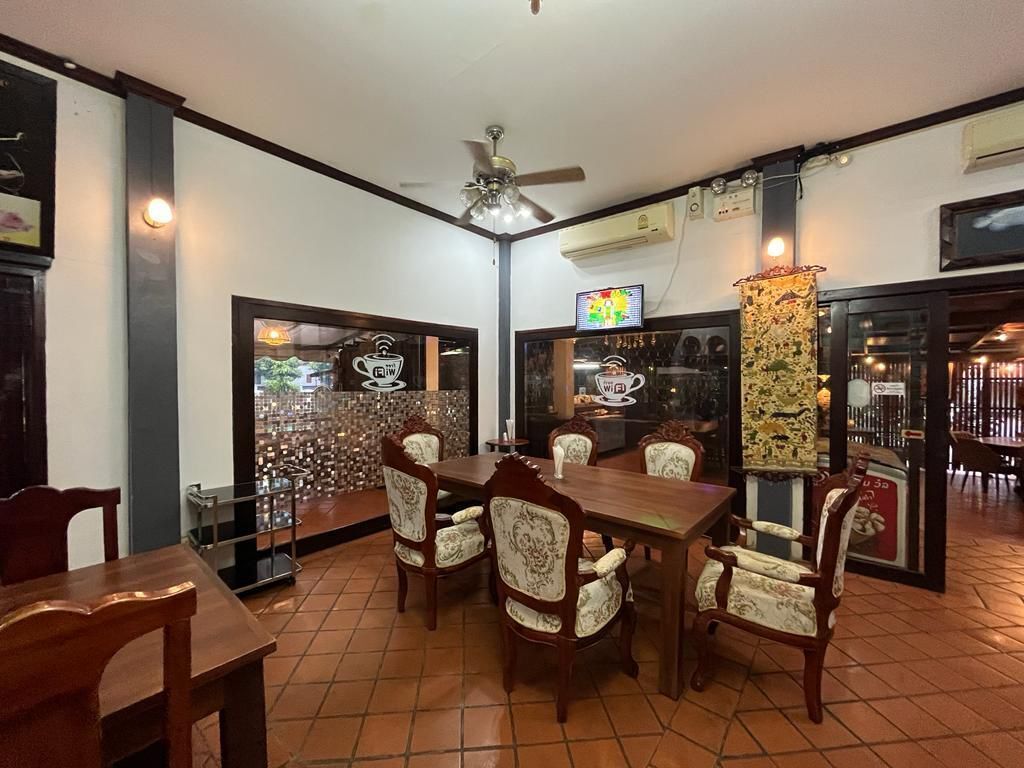 A dining area with a wooden table and chairs, a ceiling fan, and a tiled floor.