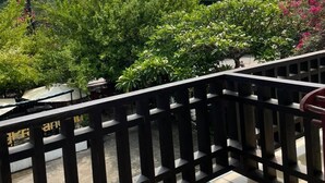 A balcony with a view of lush greenery and power lines. - Luang Prabang Inn (Luang Prabang)