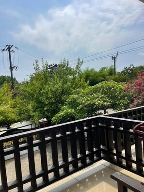 A balcony with a view of lush greenery and power lines. - Luang Prabang Inn (Luang Prabang)