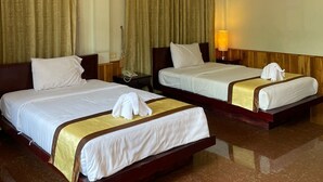 A hotel room with two beds, a wooden headboard, a marble floor, and a large window with curtains. - Luang Prabang Inn (Luang Prabang)