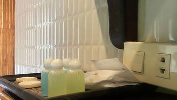 A kitchen counter with a tray holding bottles and a white towel.
