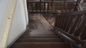 A wooden staircase with a metal railing. - Mao Phashok Guesthouse (Luang Prabang)