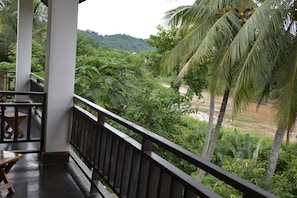 Een balkon met uitzicht op weelderige begroeiing en een rivier.