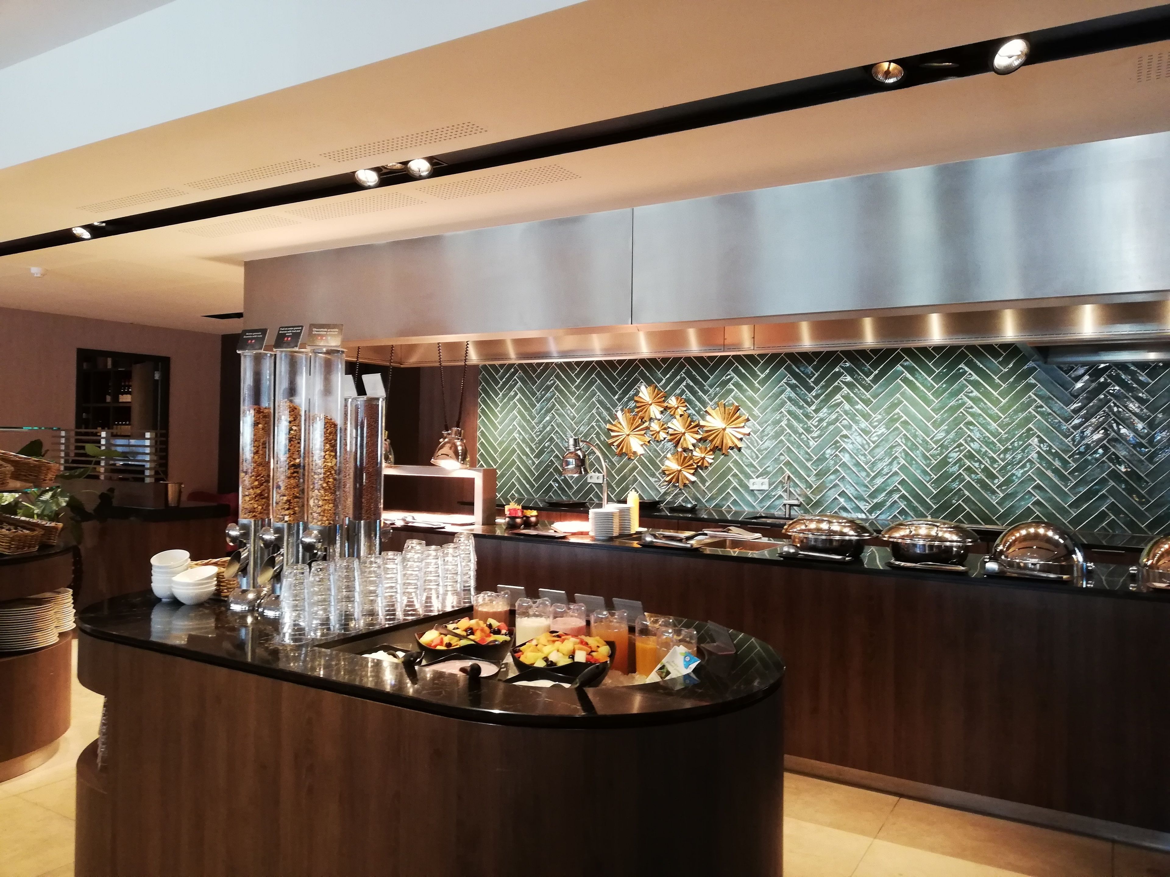 A modern breakfast bar with a variety of food and drink options, including fruits, cereals, and beverages.