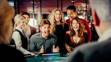 Eine Gruppe von Menschen versammelt sich um einen Casinotisch mit einem Dealer.