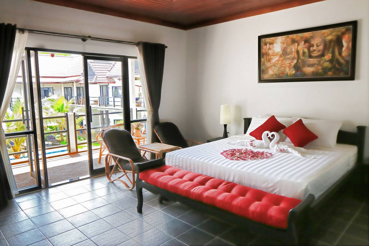 Habitación de hotel con cama, una silla, una mesa y vista al exterior.