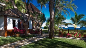 A beachfront property with a pathway leading to a house, surrounded by palm trees and a view of the ocean. - Le Saint Alexis (Saint-Paul)