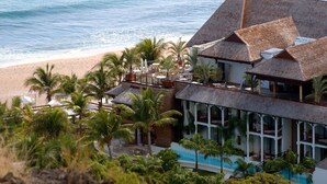 A beachfront hotel with a pool, palm trees, and ocean views. - Le Saint Alexis (Saint-Paul)