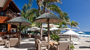 A beachside resort with outdoor seating, umbrellas, and a bar area. - Le Saint Alexis (Saint-Paul)