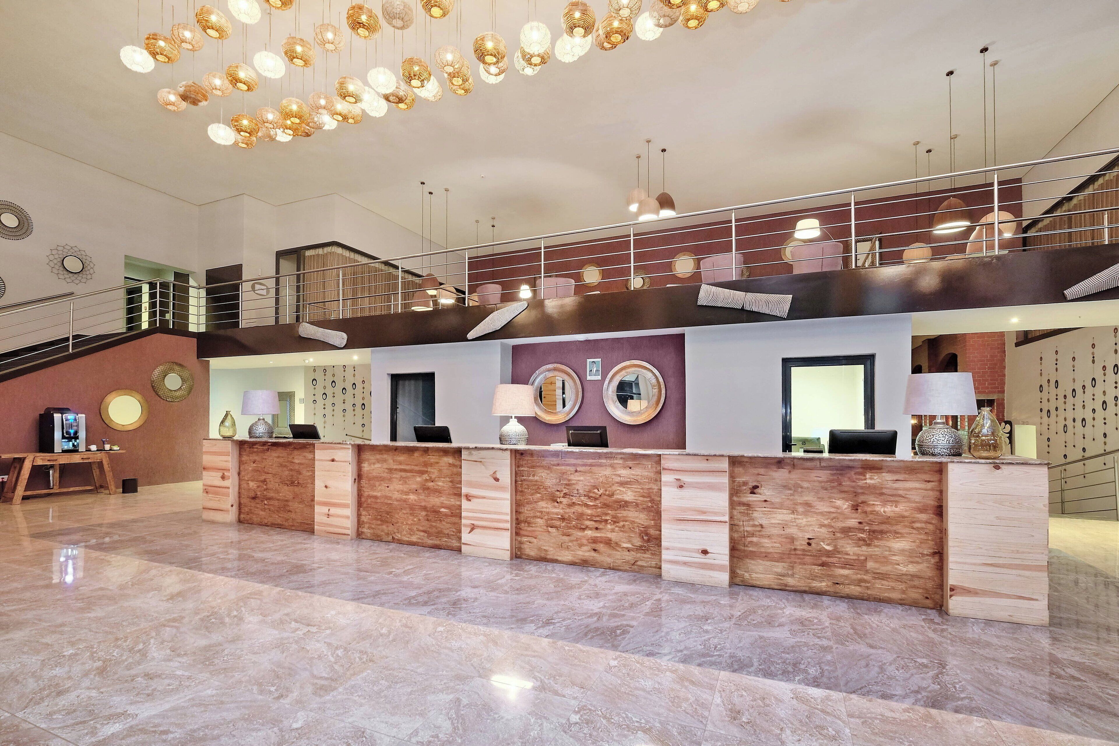Un vestíbulo amplio con una mesa de recepción, una escalera y un candelabro moderno.