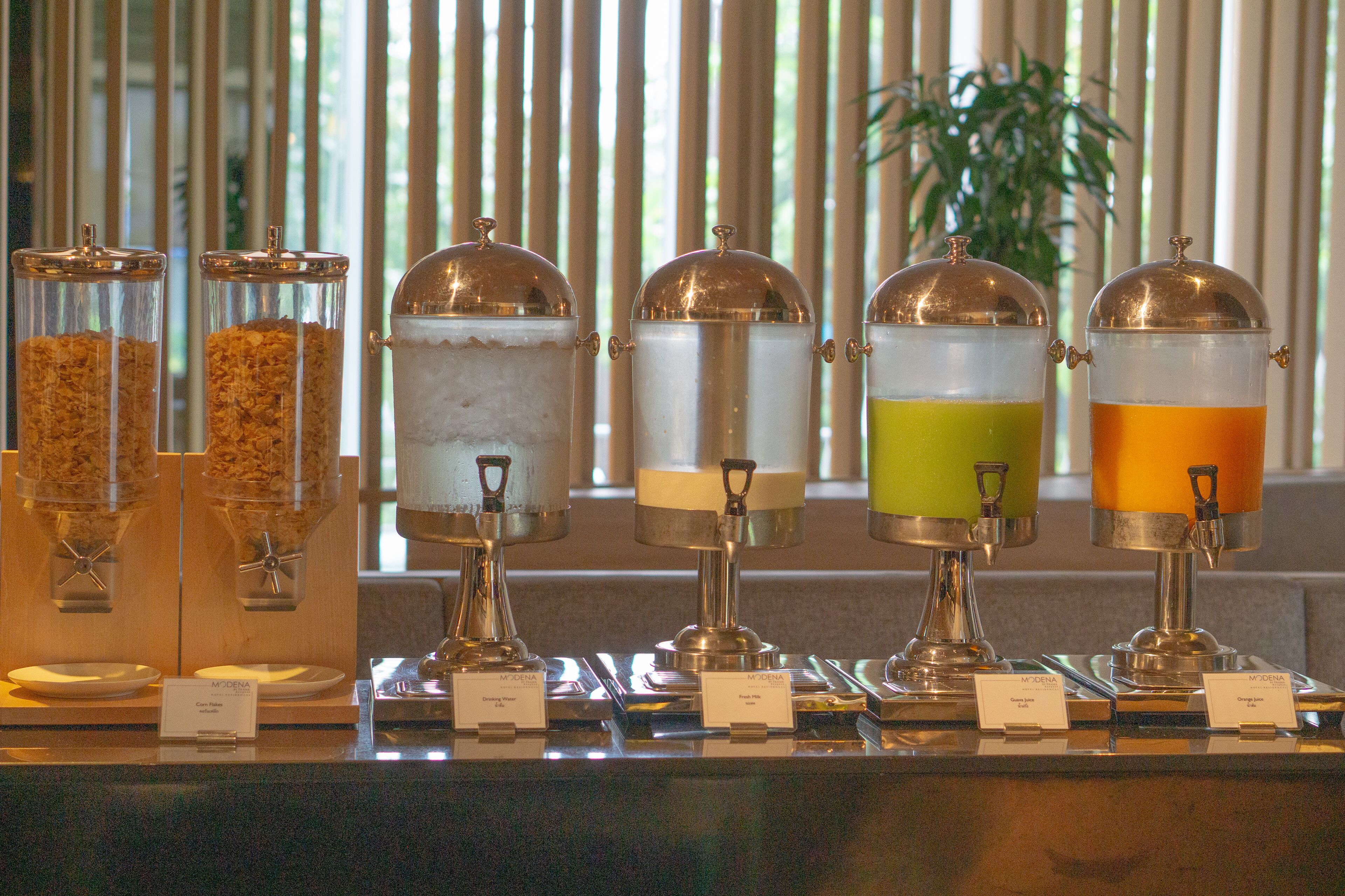 A breakfast buffet with various food options and clear signage.