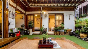 Une pièce de style japonais traditionnel, avec un sol recouvert de tatamis, un plafond en bois et une vue sur un jardin.