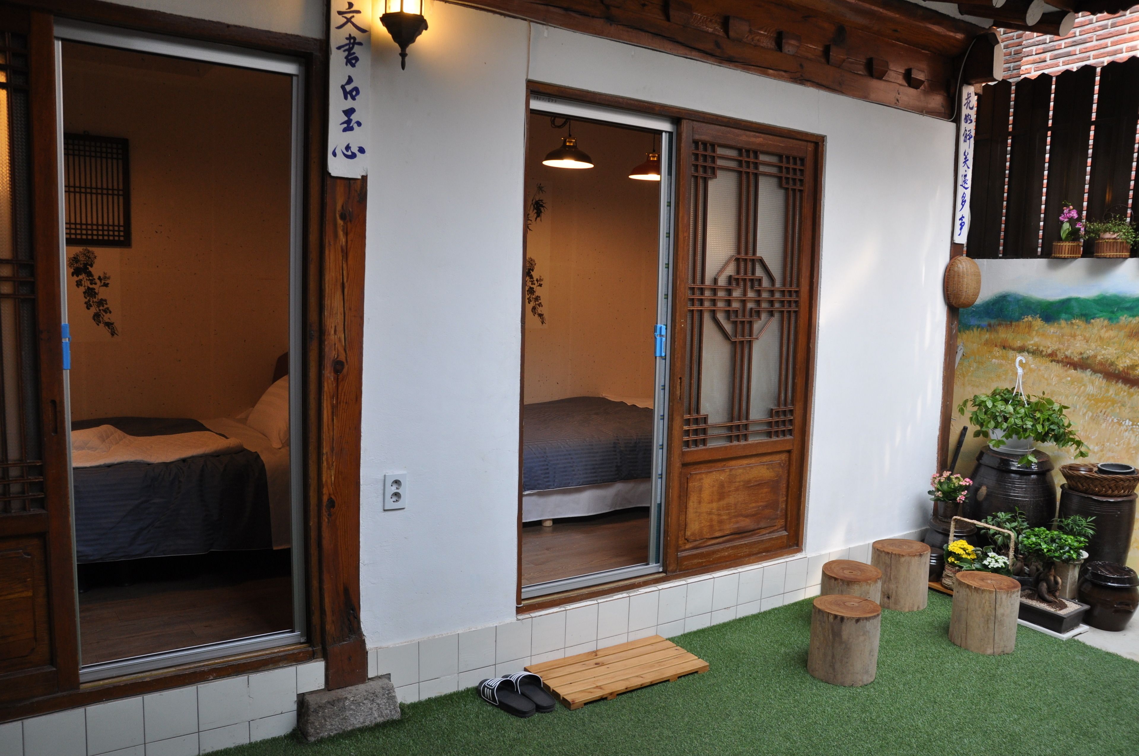 Une pièce de style japonais traditionnel, avec des portes coulissantes, un lit et un petit banc en bois à l’extérieur.