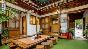 Une auberge japonaise traditionnelle avec des tatamis au sol, des meubles en bois et une table centrale également recouverte de tatamis.
