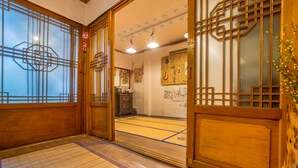 Une pièce de style japonais traditionnel, avec un sol recouvert de tatamis, des portes coulissantes en bois et un paravent shoji.