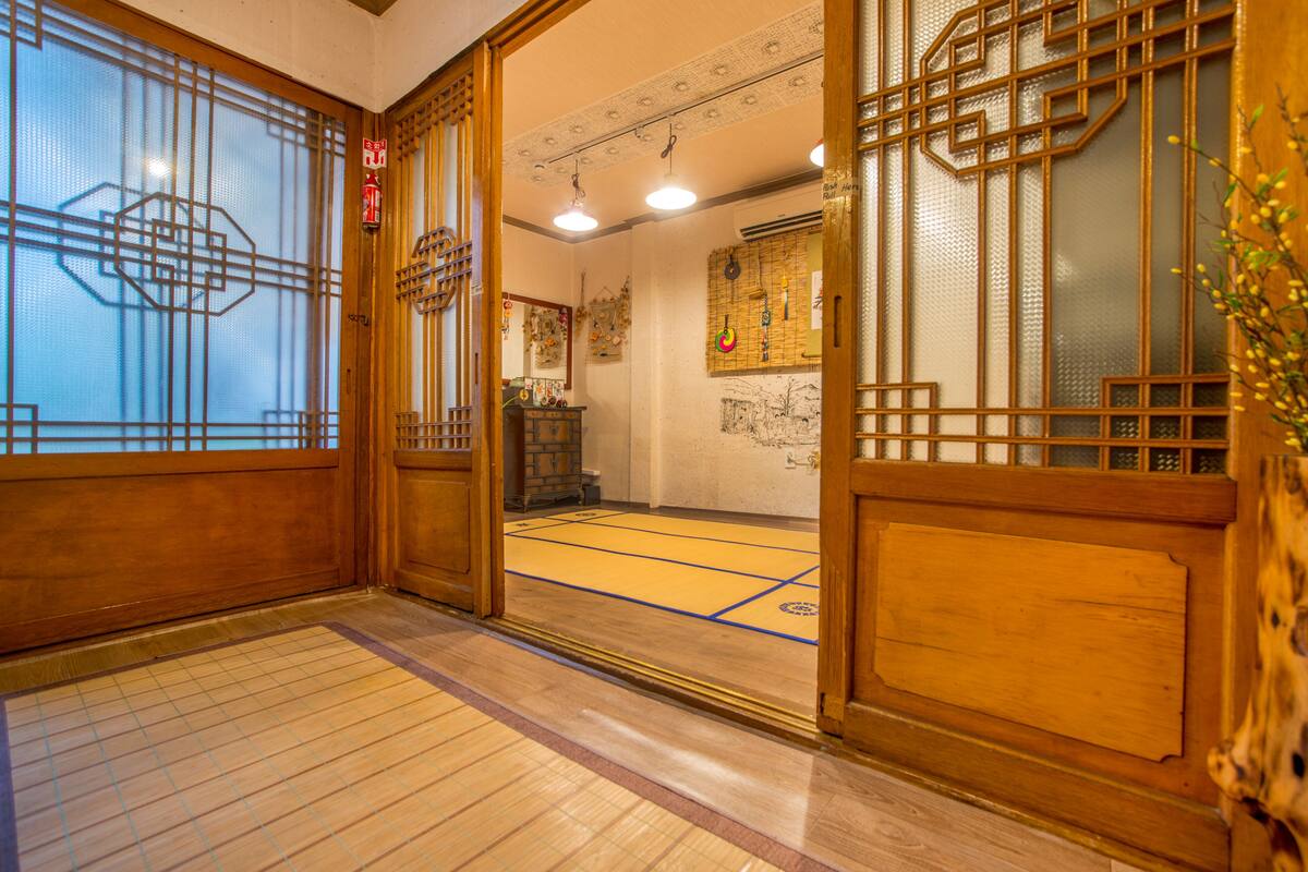 A traditional Japanese room with tatami flooring, wooden sliding doors, and a shoji screen.