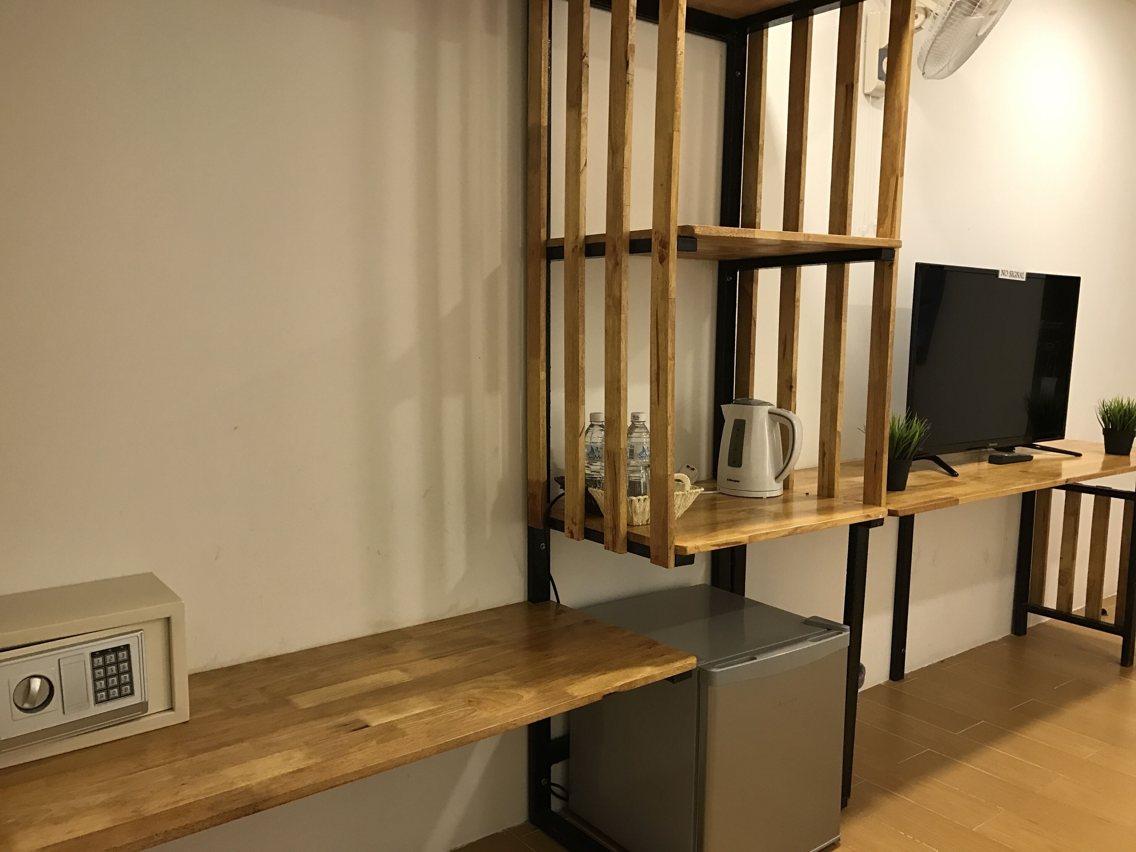 A compact living space with a kitchenette, a television, and a small refrigerator.